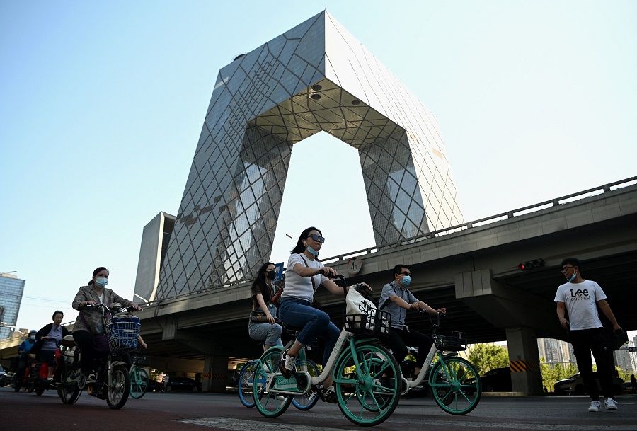 This photo taken on 3 June 2021 shows people cycling along a street during the rush hour in Beijing, China. (Noel Celis/AFP)