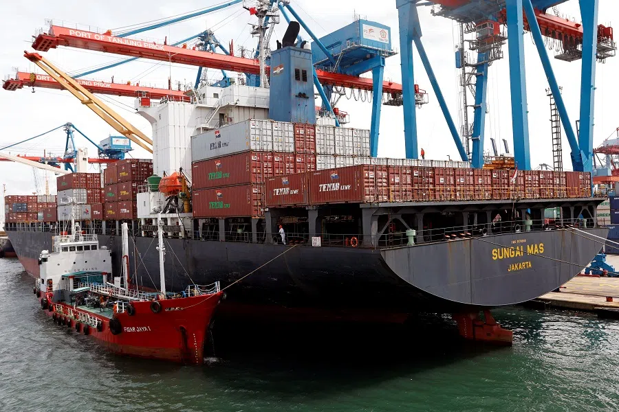 Workers are seen on a ship carrying containers at the Port of Tanjung Priok in Jakarta, Indonesia, 11 January 2021. (Willy Kurniawan/Reuters)