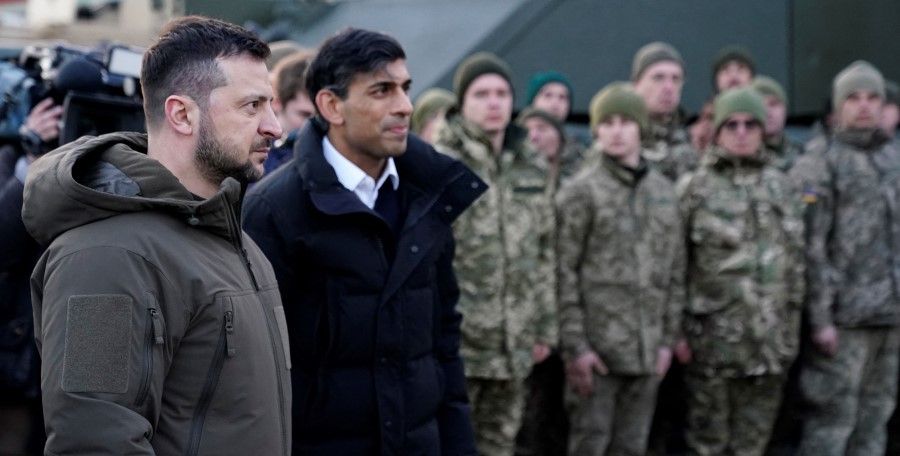 Ukraine's President Volodymyr Zelenskyy (left) and Britain's Prime Minister Rishi Sunak (centre) meet Ukrainian troops being trained to command Challenger 2 tanks at a military facility in Lulworth, Dorset in southern England on 8 February 2023. (Andrew Matthews/POOL / AFP)