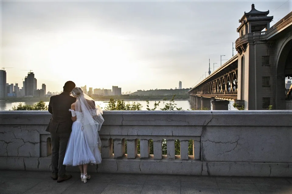 A couple poses for a wedding photographer as they postponed their marriage due to the Covid-19 pandemic, in Wuhan, China, on 14 April 2020. (Hector Retamal/AFP)