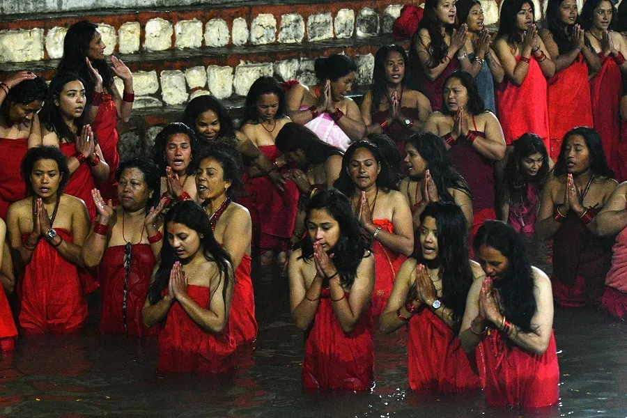 Hindu devotees perform rituals as they bathe in the Shali river during the Swasthani Brata Katha festival, in Sankhu on the outskirts of Kathmandu, Nepal, on 6 January 2023. (Prakash Mathema/AFP)
