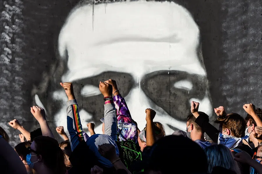 People raise their hands as they protest at the makeshift memorial in honour of George Floyd, on 4 June 2020, in Minneapolis, Minnesota. (Chandan Khanna/AFP)
