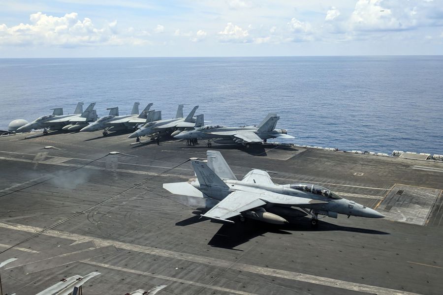 This photograph taken on 16 October 2019 shows a US Navy F/A-18 Super Hornets multirole fighter landing on the flight deck of USS Ronald Reagan (CVN-76) aircraft carrier as it sails in South China Sea. (Catherine Lai/AFP)