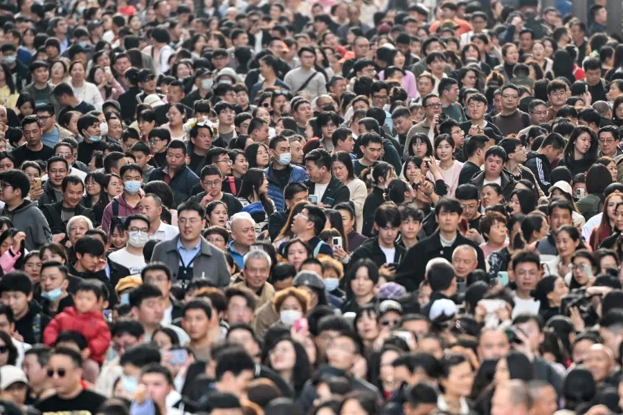 People visit a pedestrian street on the Bund during the fifth day of the Lunar New Year of the Dragon in Shanghai on 14 February 2024. (Hector Retamal/AFP)
