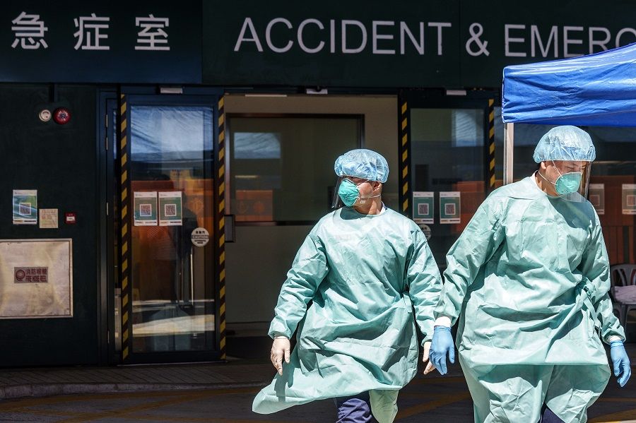 Healthcare workers wearing personal protective equipment (PPE) outside the emergency department at Caritas Medical Centre hospital in Hong Kong, China, on 8 March 2022. (Lam Yik/Bloomberg)