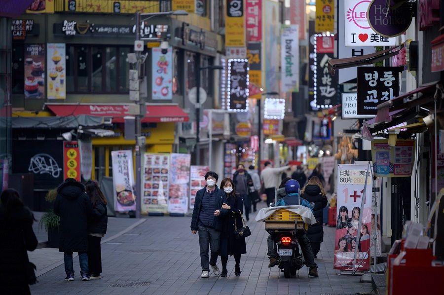 Shoppers walk along a street in the Myeongdong district of Seoul on 28 December 2020. (Ed Jones/AFP)
