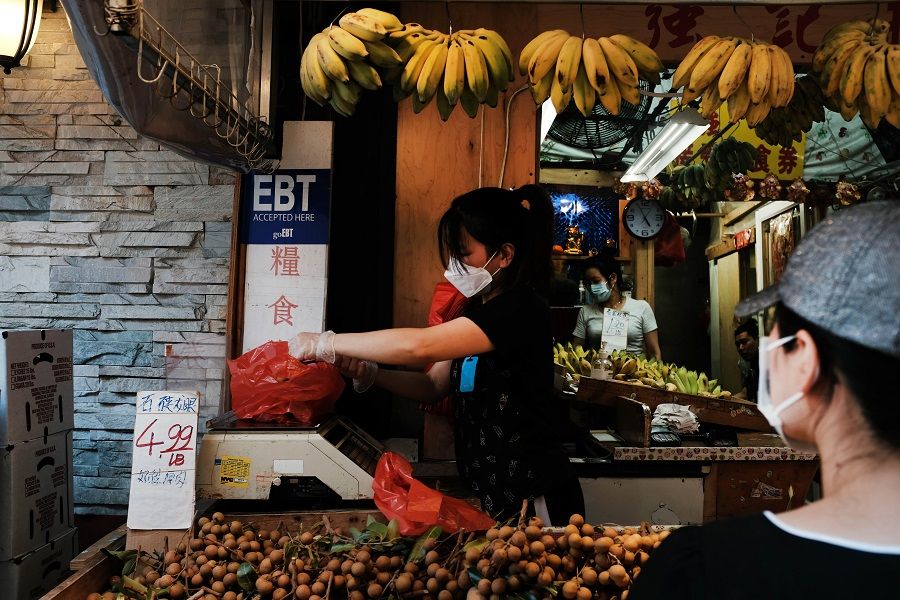 A vendor wearing a protective face mask works in New York City's Chinatown on 10 August 2020 in New York City. (Spencer Platt/Getty Images/AFP)
