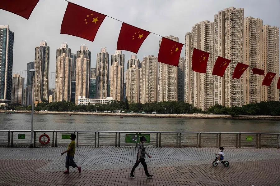 People walk along the promenade in Tsing Yi, Hong Kong, China, on 23 September 2022. (Isaac Lawrence/AFP)