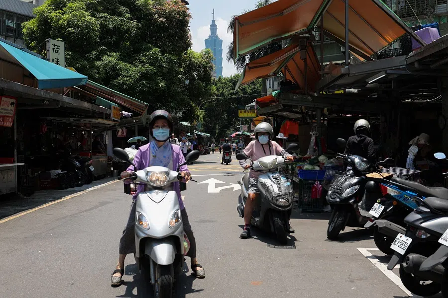 People ride scooters on a street in Taipei, Taiwan, on 17 July 2024. (Ann Wang/Reuters)