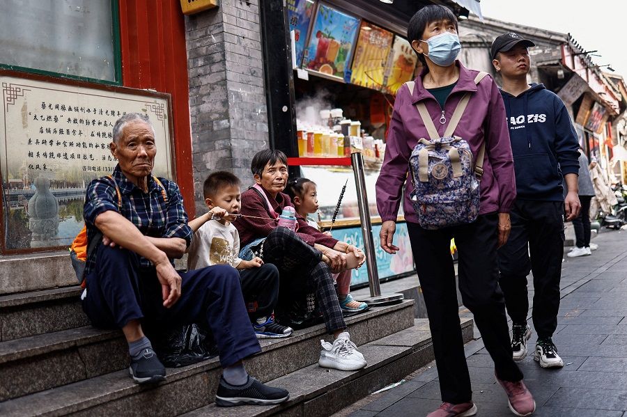 People walk past a hutong alley in Beijing, China, on 17 October 2023. (Tingshu Wang/Reuters)