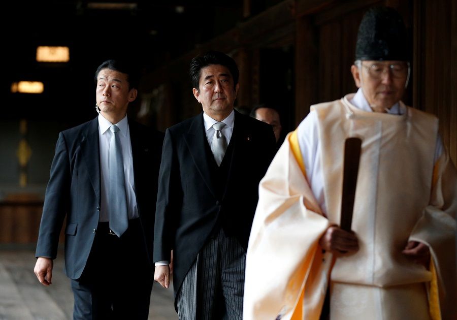 Japan Prime Minister Shinzo Abe (centre) is led by a Shinto priest as he visits Yasukuni shrine in Tokyo, 26 December 2013. (Toru Hanai/File Photo/Reuters)