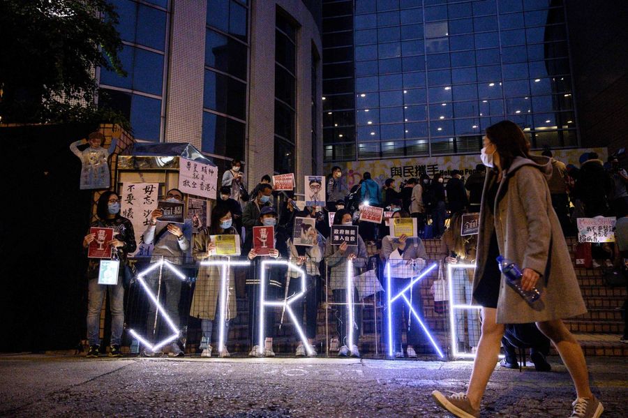 A light installation reading "strike" stands before members of the Hospital Authority Employees Alliance and other activists at the Hospital Authority building in Hong Kong on 7 February 2020, calling for the government to close its border with mainland China to contain the new coronavirus epidemic. (Philip Fong/AFP)