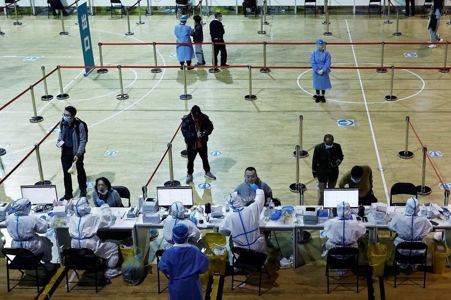 Medical workers in protective suits collect swabs from residents at a nucleic acid testing centre inside a stadium in Shanghai, China, 14 March 2022. (CNS photo via Reuters)