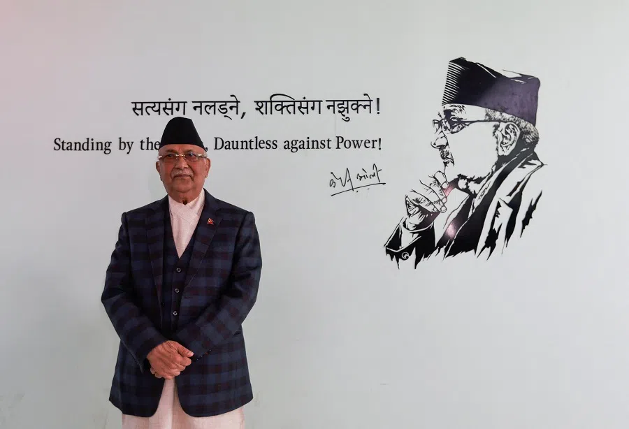 Former Prime Minister K.P. Sharma Oli who heads the Communist Unified Marxist-Leninist (UML) party of Nepal poses for a picture as he stands near his portrait outside his office in Lalitpur, Nepal, 2 November 2022. (Navesh Chitrakar/Reuters)