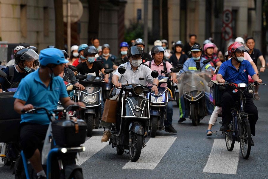 People ride electric scooters during rush hour in Shanghai, China, on 3 September 2021. (Greg Baker/AFP)