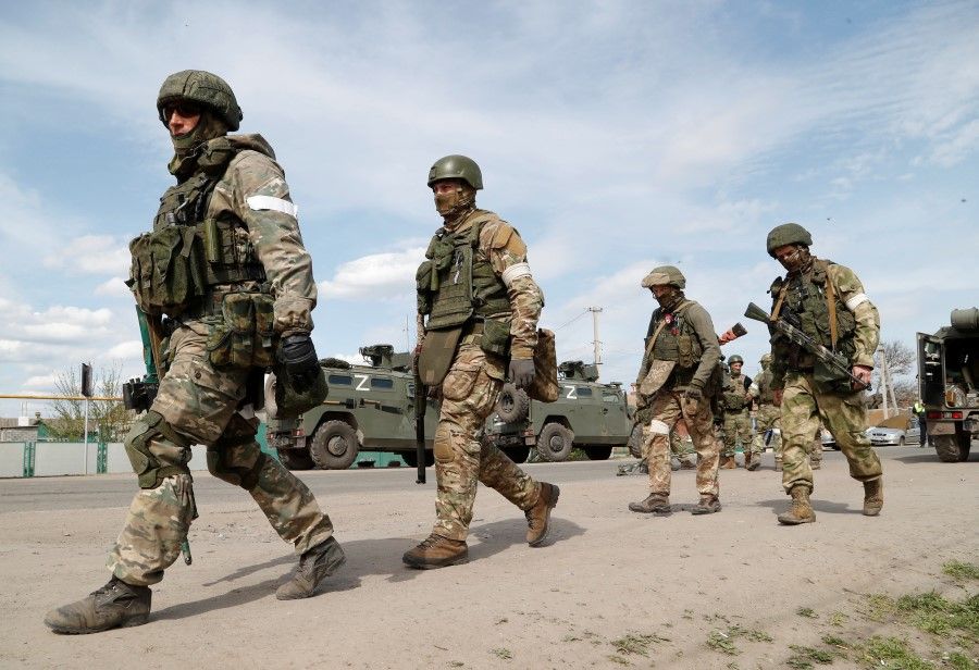 Service members of pro-Russian troops walk near a temporary accommodation centre for evacuees during the Ukraine-Russia conflict in the village of Bezimenne in the Donetsk Region, Ukraine, 1 May 2022. (Alexander Ermochenko/Reuters)