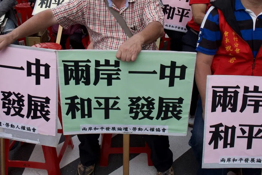 This picture taken on 18 May 2016 shows pro-unification activists displaying placards that read "Both shores all belong to one China" during a rally in Taipei. Beijing views Taiwan as part of China and has intensified pressure on Taipei to dizzying highs in recent months.(Sam Yeh/AFP)