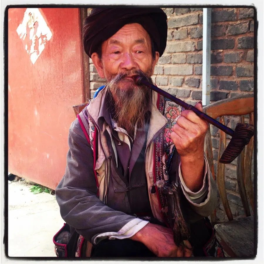 Taking a break. A local at the market in Shigu (石鼓古镇) smoking a pipe.