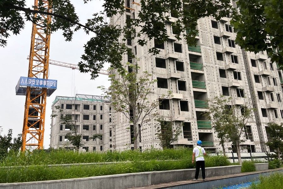 A worker looks on at a construction site of residential buildings by Chinese developer Country Garden, in Beijing, China, on 11 August 2023. (Tingshu Wang/Reuters)