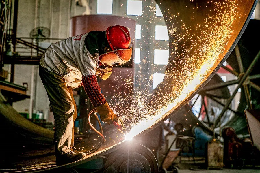 Sparks fly up as a worker produces engineering equipment for export at a factory in Nantong, Jiangsu province, China, on 30 March 2021. (STR/AFP)