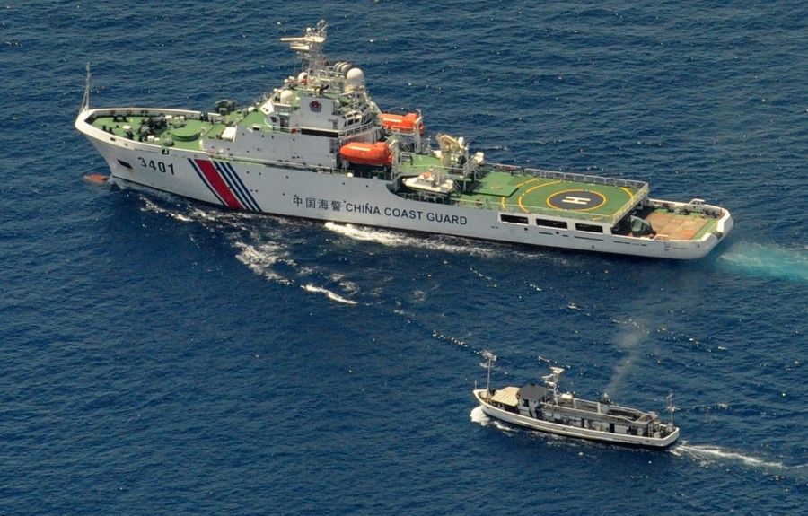 This file photo taken on 19 March 2014 shows a China Coast Guard ship (top) and a Philippine supply boat engaging in a stand off as the Philippine boat attempts to reach the Second Thomas Shoal, a remote South China Sea reef claimed by both countries. (Jay Directo/AFP)