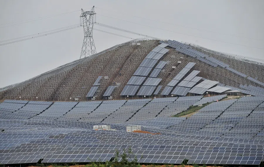 An electricity pylon is seen above a solar power plant which is under construction on a hill in Wuhu, Anhui province, China, 16 September 2014. (Stringer/File Photo/Reuters)
