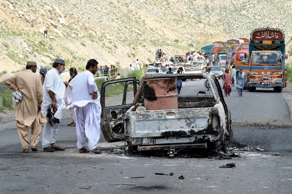 People look at a charred vehicle near a collapsed railway bridge the morning after a blast by separatist militants at Kolpur in Bolan district, Balochistan province on 27 August 2024. (AFP)