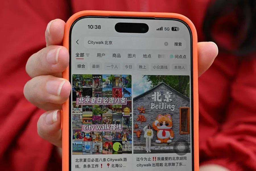 A tourist from Hunan province shows her RedNote account on her mobile phone while visiting the Forbidden City in Beijing on 11 July 2026.