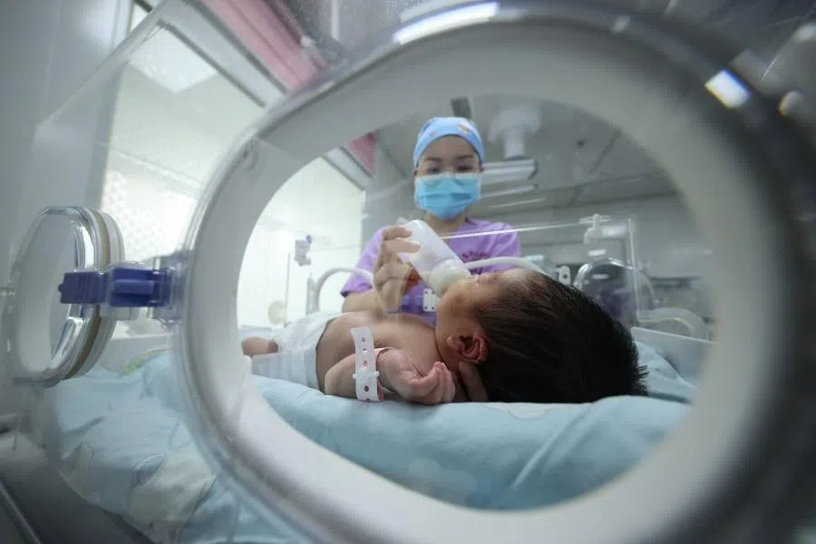 A medical staff member feeds a baby at a hospital in Danzhai in China’s southwestern Guizhou province on 11 May 2021.
