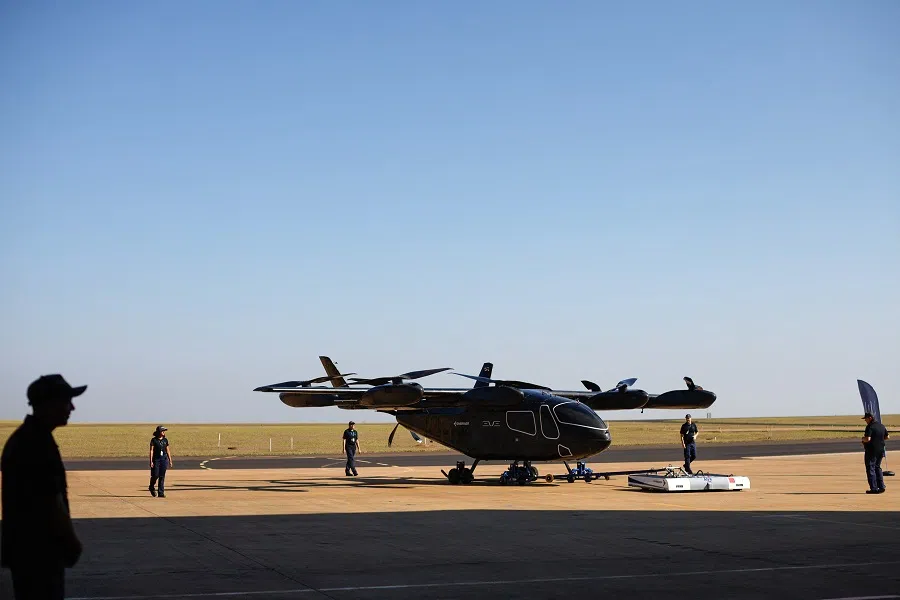 Employees work near the full-scale prototype of electric vertical take-off and landing (eVTOL) aircraft developed by Eve Air Mobility, an Embraer group company, as it is presented for the first time in Gaviao Peixoto, Brazil, on 3 July 2024. (Amanda Perobelli/Reuters)