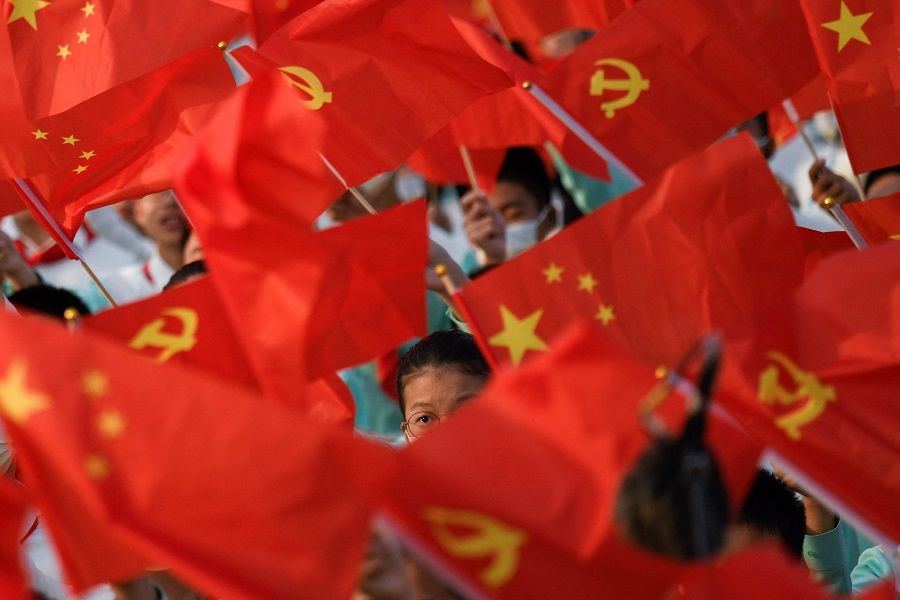 Students wave flags of China and the Communist Party of China before celebrations in Beijing, China, on 1 July 2021, to mark the 100th anniversary of the founding of the Communist Party of China. (Wang Zhao/AFP)