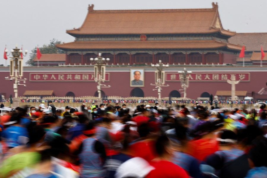 Participants run past Tiananmen Gate during the Beijing Marathon in Beijing, China, 6 November 2022. (Tingshu Wang/Reuters)