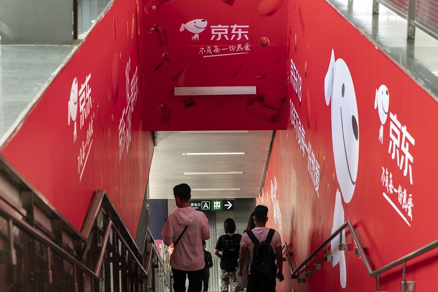 Pedestrians walk past a JD.com Inc. advertisement at a subway station in Beijing, China on 26 May 2021. (Qilai Shen/Bloomberg)