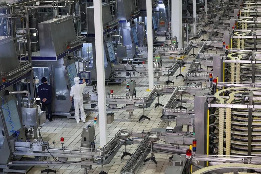 Employees work at Mengniu milk processing factory during organised media tour in Hohhot, Inner Mongolia Autonomous Region, China, on 11 June 2026.