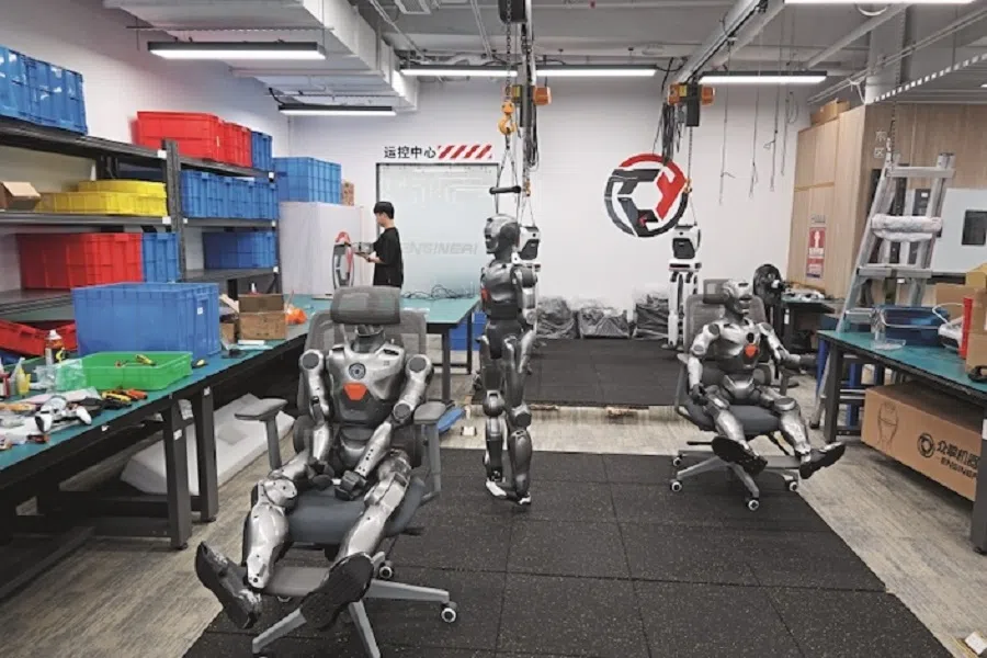A staff member organises components in EngineAI’s robotics lab on 10 March 2025. (Photo: Du Zhihang/Caixin)