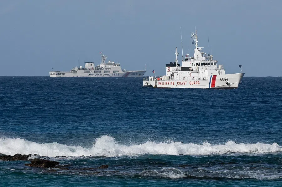 A China Coast Guard vessel (left) and a Philippine Coast Guard vessel are seen near Thitu Island in the disputed South China Sea on 1 December 2023. (Jam Sta Rosa/AFP)
