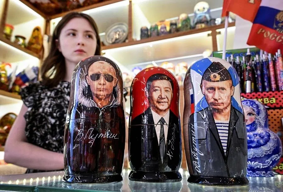 A vendor offers traditional Russian wooden nesting dolls, Matryoshka dolls, depicting Russian President Vladimir Putin and Chinese President Xi Jinping at a gift shop in downtown Moscow on 19 May 2026.