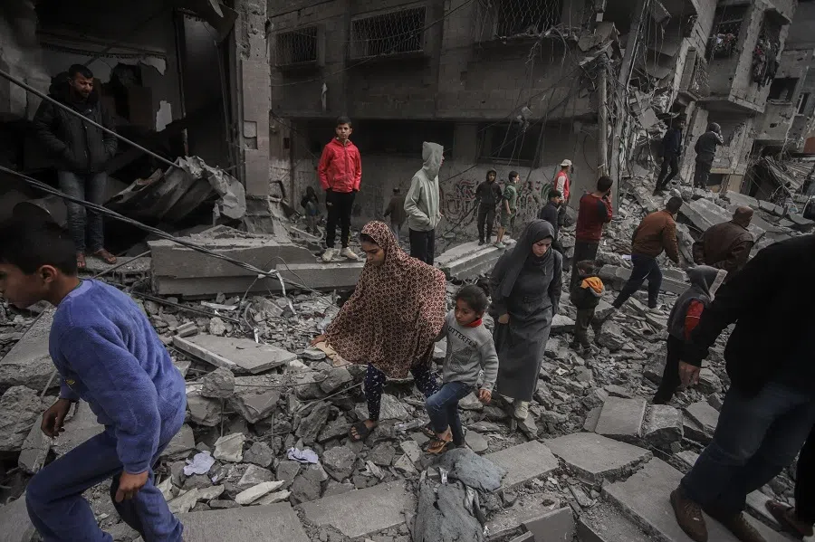 Palestinians clamber across building rubble following an Israeli airstrike at the Nuseirat refugee camp in central Gaza, on 27 November 2024. As the ceasefire between Israel and Hezbollah holds, an Egyptian security team is reportedly traveling to Israel for talks over Gaza. (Ahmad Salem/Bloomberg)