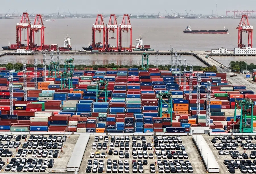 A drone view shows electric vehicles for export and containers sitting at a port in Shanghai, China, on 13 April 2025.