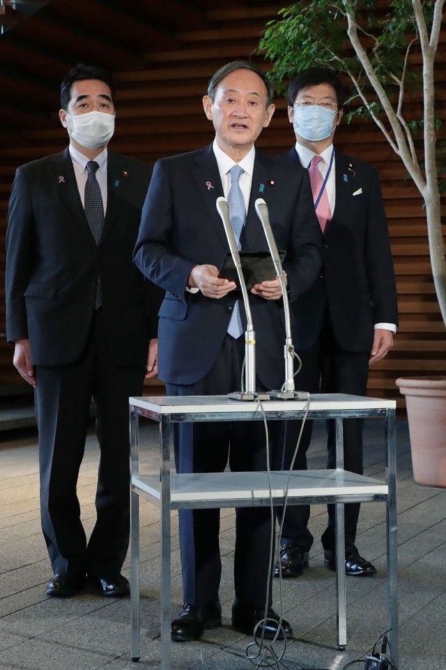 Japanese Prime Minister Yoshihide Suga (centre) speaks to the reporters after his telephone talk with US President-elect Joe Biden, at the prime minister's official residence in Tokyo on 12 November 2020. (STR/Jiji Press/AFP)