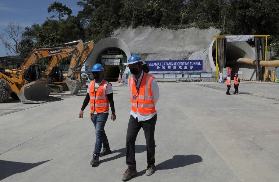 Workers walk at the construction site of East Coast Rail Link (ECRL), a Chinese-invested railway project part of the Beijing 'Belt and Road Initiative', in Bentong, Malaysia, 13 January 2022. (Hasnoor Hussain/Reuters)