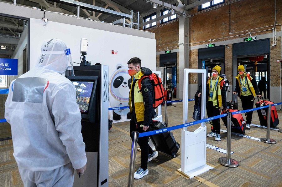 Members of Team Germany go through security after arriving at the Olympic Village ahead of the Beijing 2022 Winter Olympic Games in Beijing, China, on 1 February 2022. (Anthony Wallace/Pool/AFP)