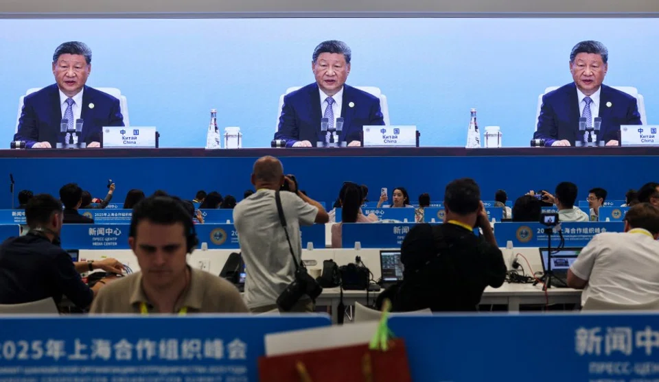 Journalists take images of a screen broadcasting Chinese President Xi Jinping delivering a speech during the plenary session of 2025 Shanghai Cooperation Organisation (SCO) summit in Tianjin, China, on 1 September 2025. (Maxim Shemetov/Reuters)