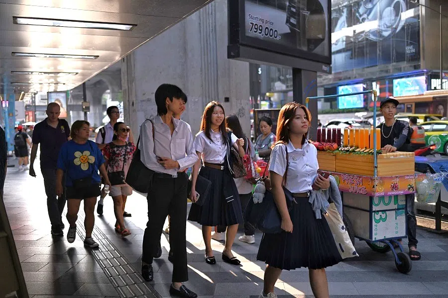 University students walk around Siam Square in Bangkok, Thailand, on 8 May 2024. (Lillian Suwanrumpha/AFP)