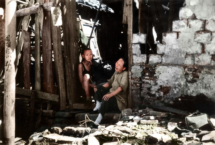 In July 1938, during the Battle of Wuhan, the Japanese army launched fierce bombing raids on Wuhan. An elderly woman sits amid the ruins of a house, wailing in despair.