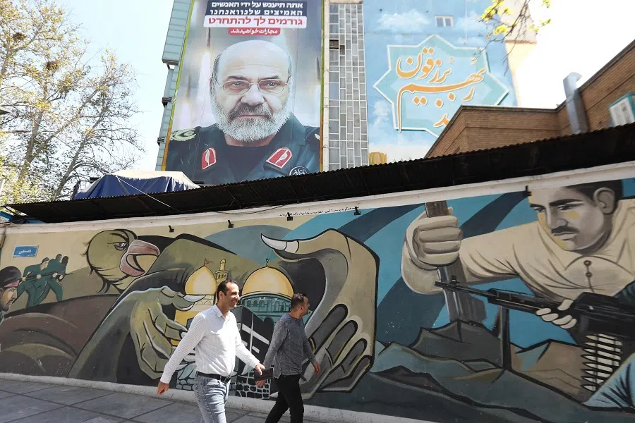 A billboard (top) displays a portrait of slain Iranian Brigadier General Mohammad Reza Zahedi with a slogan in Hebrew saying, "You will be punished", on 3 April 2024 at Palestine Square in Tehran, after he was killed in a strike at the consular annexe of the Iranian embassy in Damascus. (Atta Kenare/AFP)