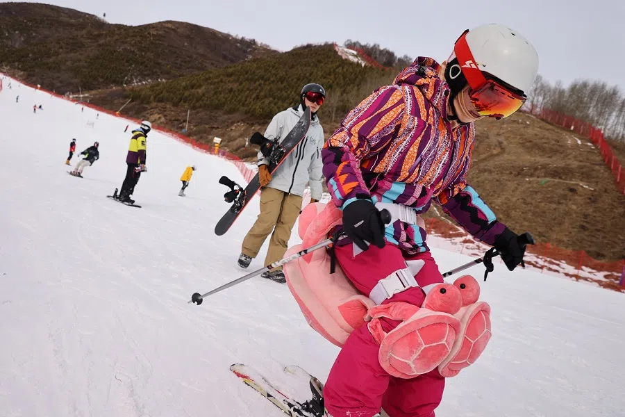 Visitors ski and ride snowboards at the Genting ski resort in Zhangjiakou close to venues for the Winter Olympics Beijing 2022, Hebei province, China, 20 November 2021. (Thomas Peter/Reuters)