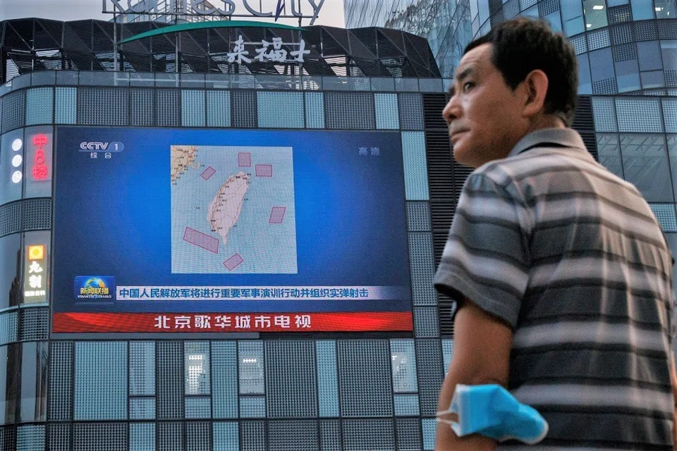 A man stands in front of a screen showing a CCTV news broadcast, featuring a map of locations around Taiwan where Chinese People's Liberation Army (PLA) will conduct military exercises and training activities including live-fire drills, at a shopping center in Beijing, China, 3 August 2022. (Thomas Peter/Reuters)