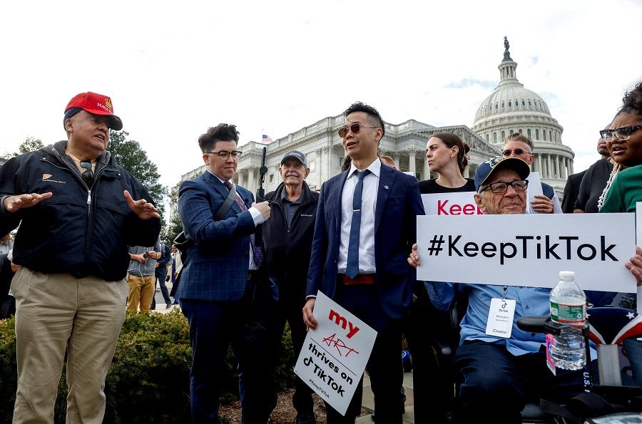 A man wearing a Maga hat who said TikTok should be banned, speaks to TikTok creators before they hold a news conference in support of TikTok, at the House Triangle at the US Capitol in Washington, US, on 22 March 2024. (Evelyn Hockstein/Reuters)