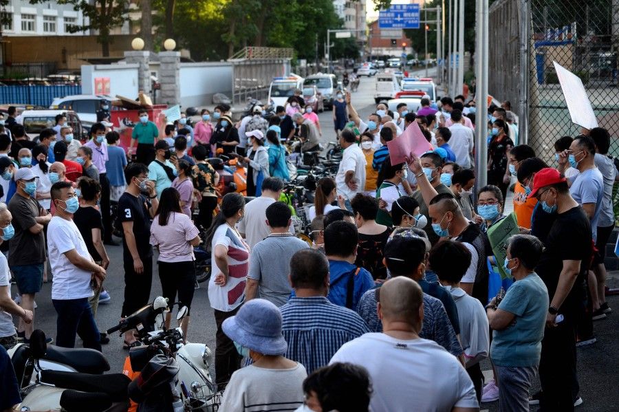 People who visited or live near Xinfadi Market queue for a swab test at Guang'an Sport Center in Beijing, 14 June 2020. (Noel Celis/AFP)